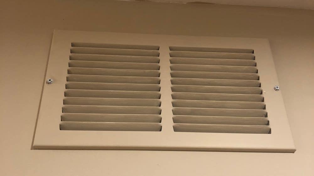 Return air grille set into a painted interior wall